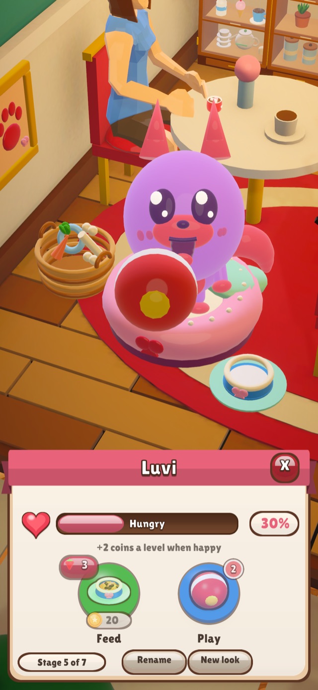 Luvi, a round purple café pet, sitting on a pink cushion next to its bowl